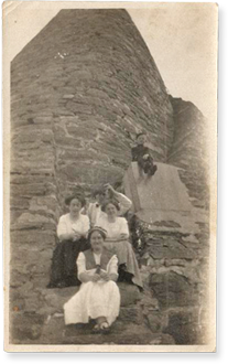 victorian ladies sitting at the bottom of a rock formation