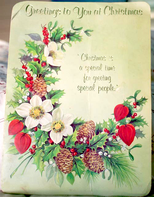 A vintage Christmas card with flowers and pine cones