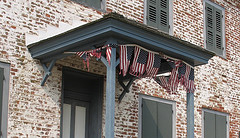 flags waving on the fourth at an old stone building